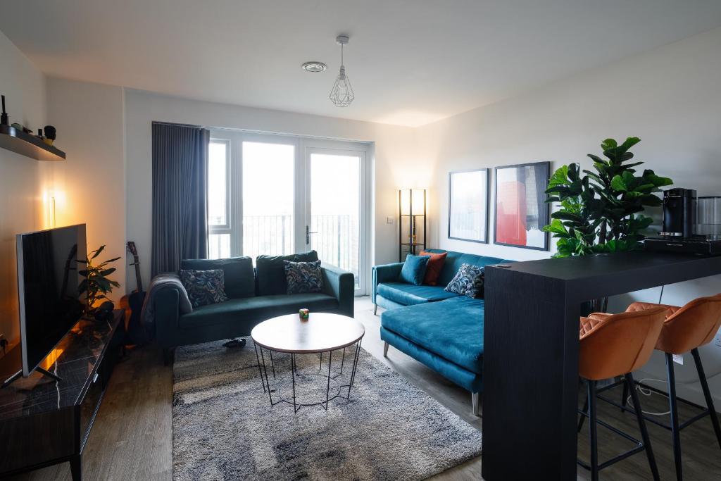 伦敦Charming 1-Bed Apartment in London的客厅配有蓝色的沙发和桌子