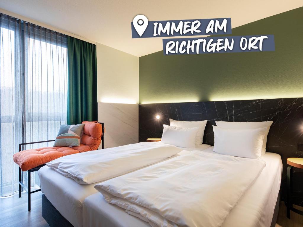 斯图加特ACHAT Hotel Stuttgart Airport Messe的配有一张床和一把椅子的酒店客房