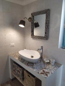 马丁纳弗兰卡Antica Storia的浴室设有水槽和镜子,位于柜台上