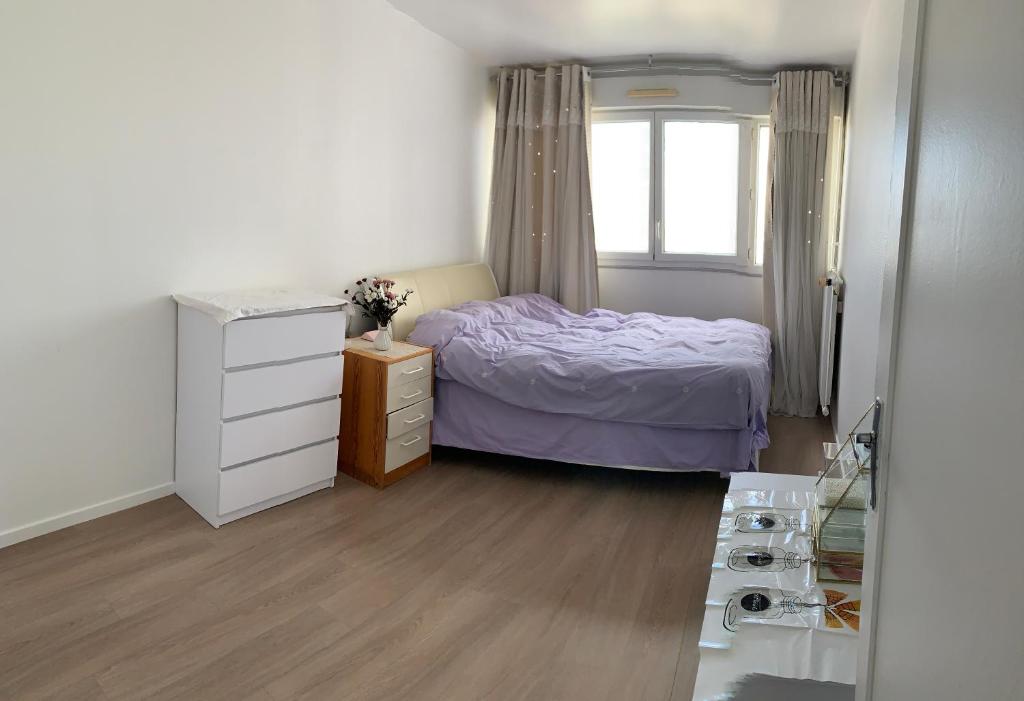 圣吉欧梅斯【Vitry-sur-Seine】 Appartements confortables de 2 chambres et 1 salon à louer的一间卧室配有一张床、一个梳妆台和一扇窗户。