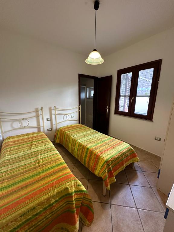 波萨达Grazioso appartamento a Posada的一间卧室设有两张床和窗户。