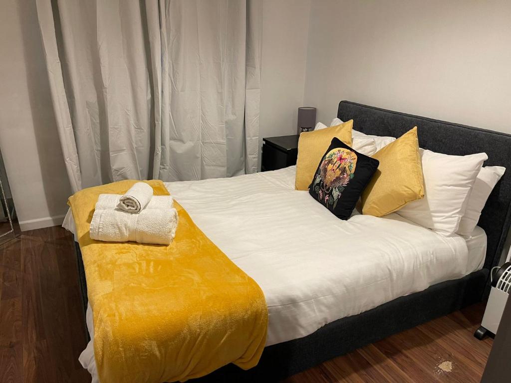 沃特福德SAV 1 Bed Apartment Argyle Watford的卧室配有一张带黄色床单和枕头的大床。
