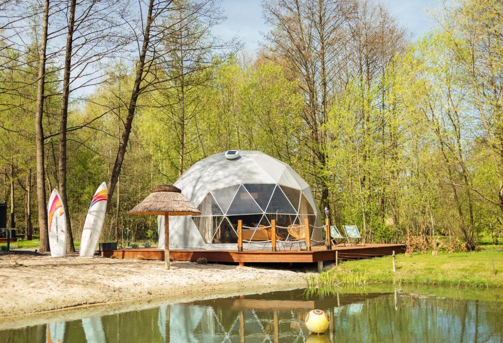 纳文丘夫Domki i Glamping Nałęczów - Pod Łysą Górą的船坞上的圆顶帐篷,靠近水体