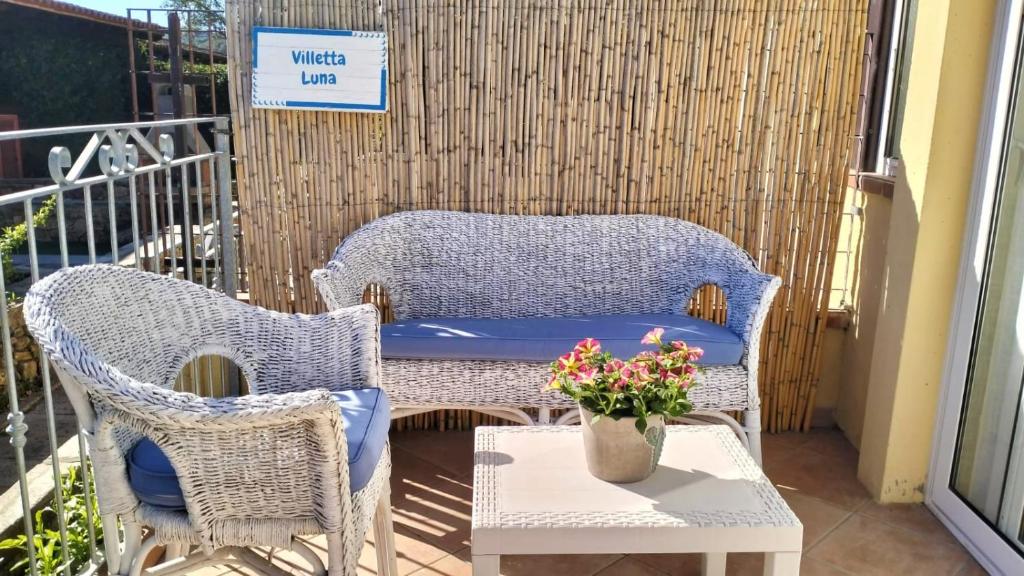 圣特奥多罗Villetta Luna的庭院设有两把藤椅和一张带鲜花的桌子