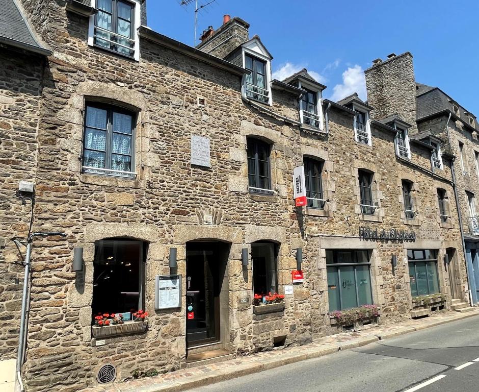 迪南Hôtel du Château Dinan - Originals Boutique的一座古老的石头建筑,窗户上有鲜花