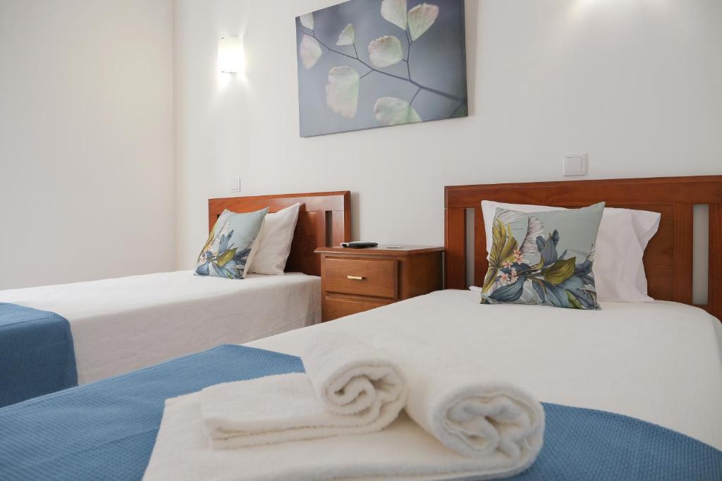 雷根古什-迪蒙萨拉什Casa do Castelo的一间卧室配有两张带白色床单的床