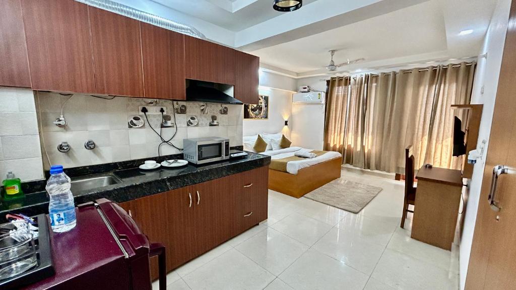 古尔冈Aura Luxury Studio Near Golf Course Road, Sector 57, Gurgaon的一间设有厨房和客厅的客房
