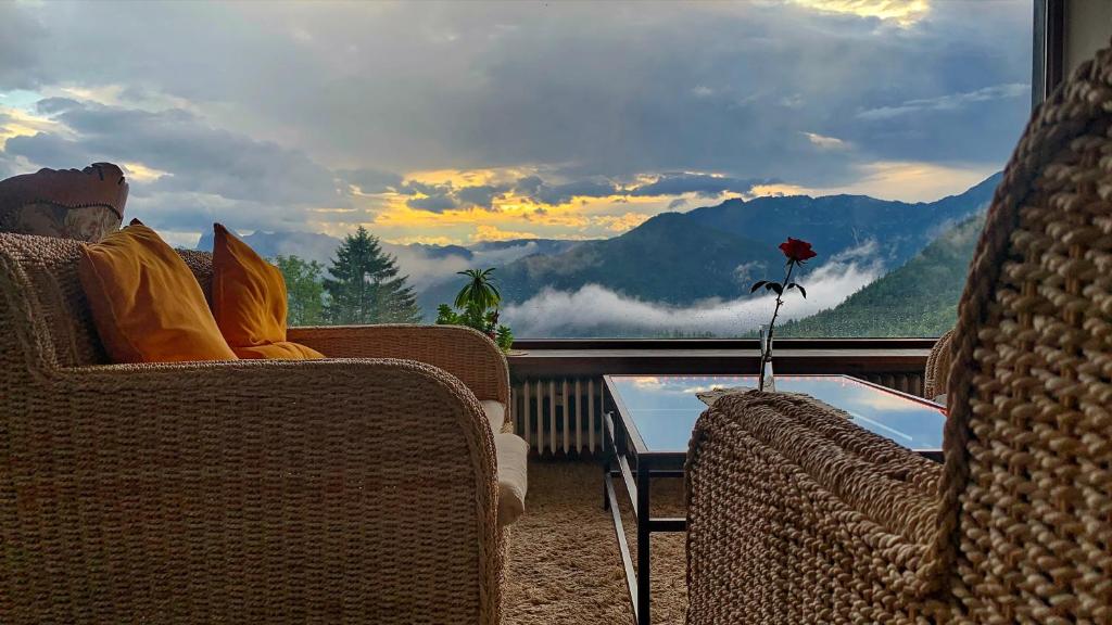 贝希特斯加登贝洛别墅酒店的坐在阳台上的椅子上,享有山景