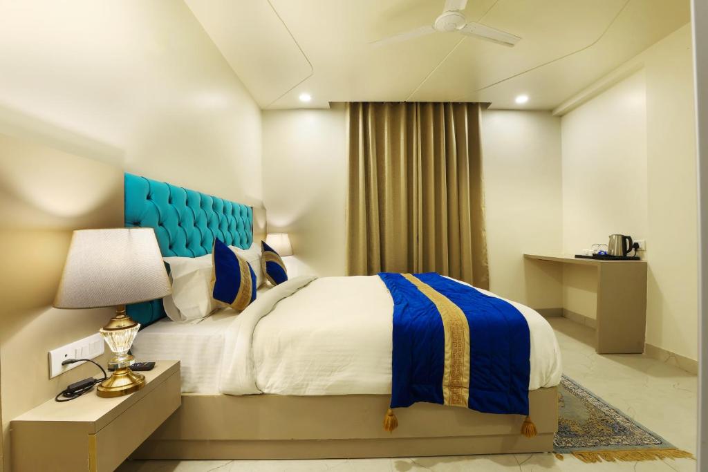 新德里OPO Hotels D'or的一间卧室配有一张床和一个蓝色床头板