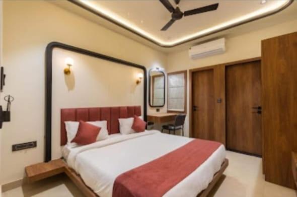 乌代浦Vaibhavya Hotel & Restaurant udaipur的一间卧室配有一张大床和一张书桌