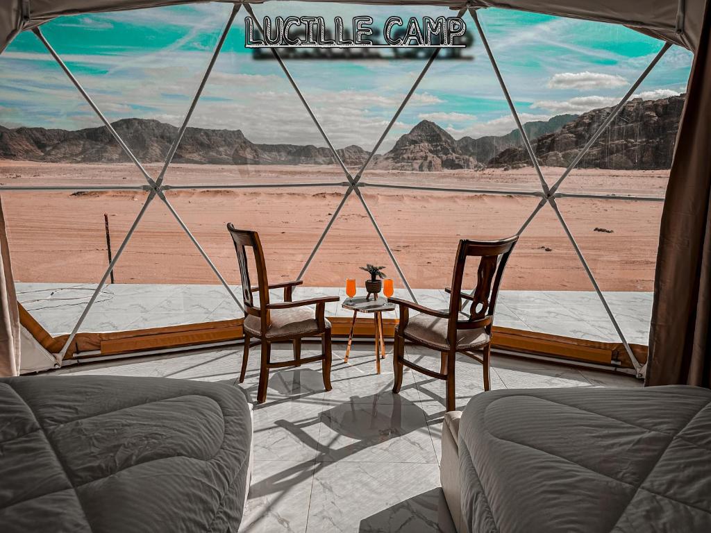 瓦迪拉姆Rum Lucille Luxury camp的帐篷配有桌椅,享有沙漠美景