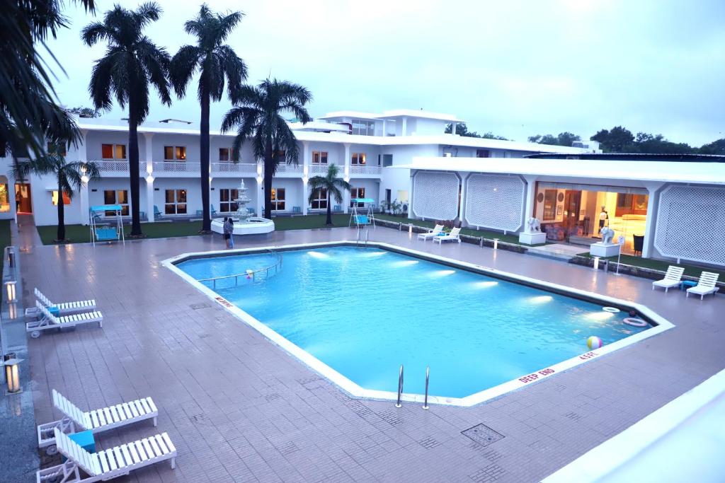 克久拉霍Hotel Chandela Khajuraho的大楼前的大型游泳池