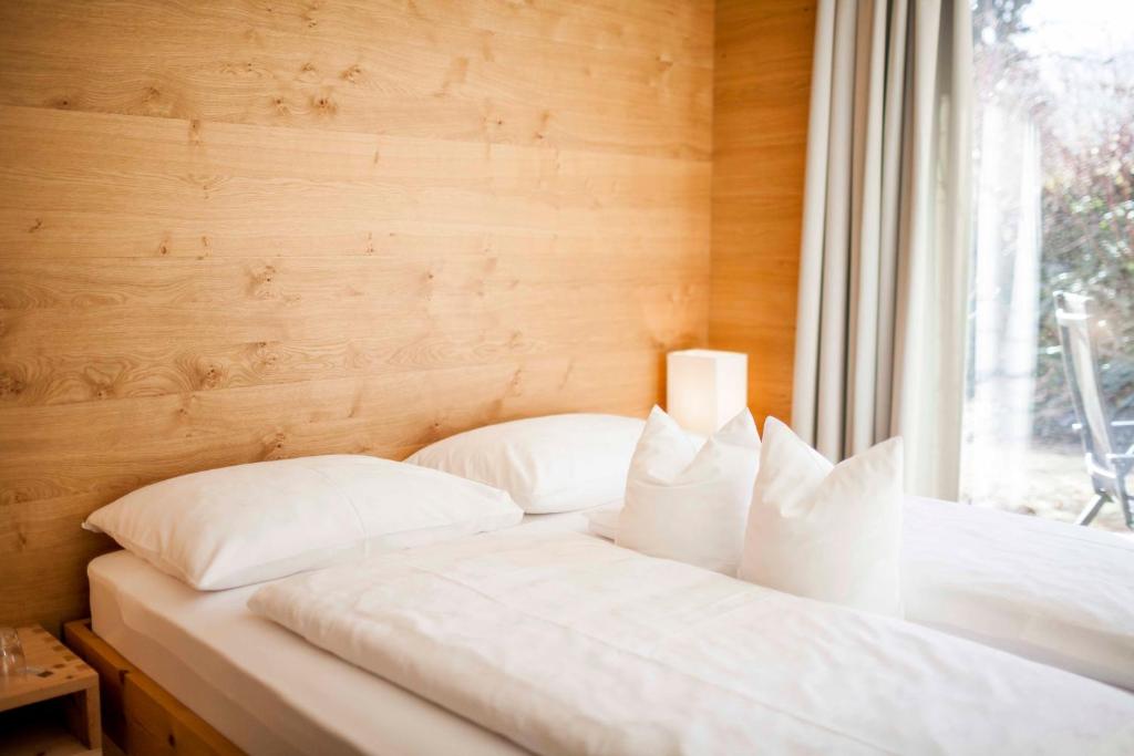 维皮泰诺Steindls Boutique Favourite的窗户客房内的一张带白色枕头的床
