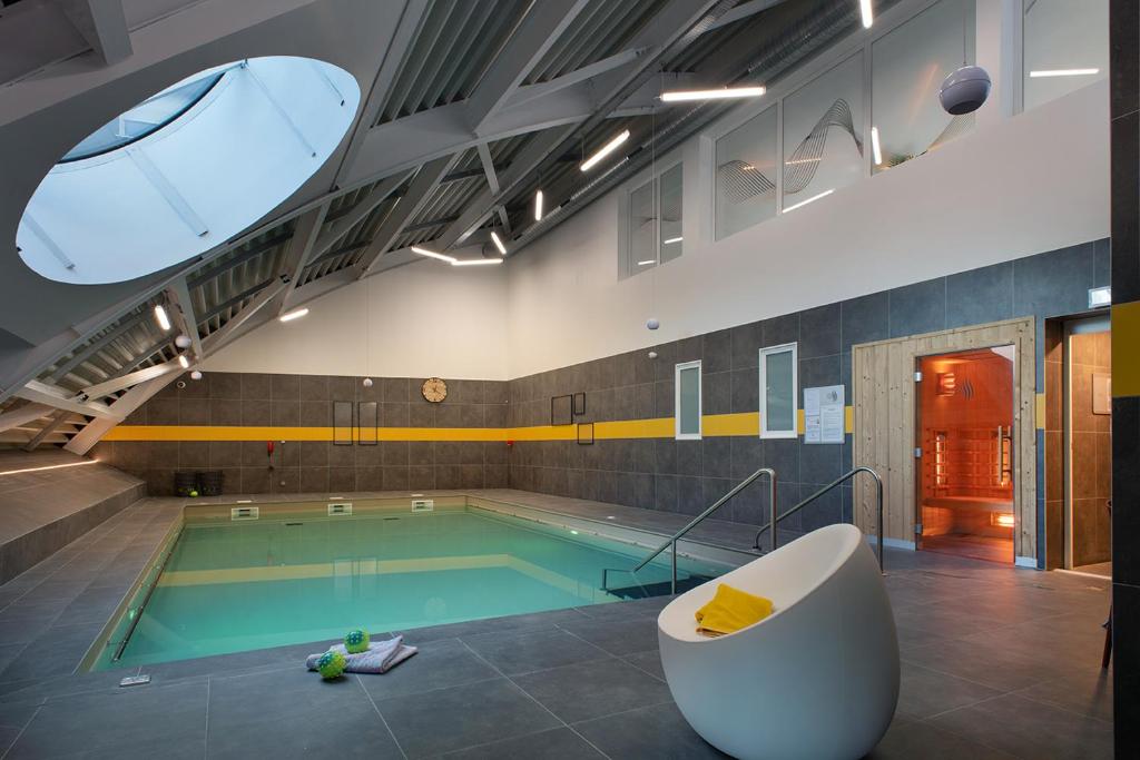 瓦朗西纳Domitys l'Esquisse的一座配有浴缸的游泳池和一座游泳池
