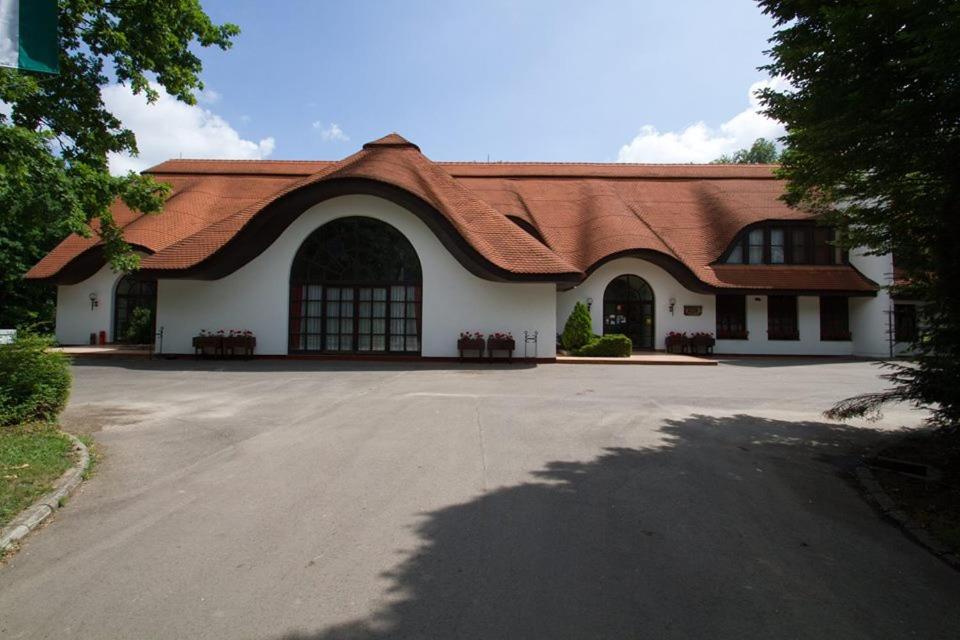 NádudvarFácánliget Rendezvényház的一座白色的大建筑,有红色的屋顶