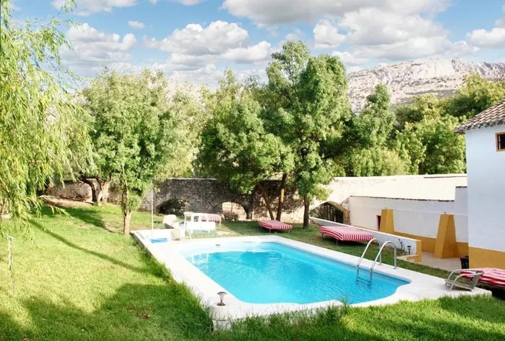 特拉武科新镇6 bedrooms villa with private pool enclosed garden and wifi at Villanueva del Trabuco的后院,草地上设有游泳池