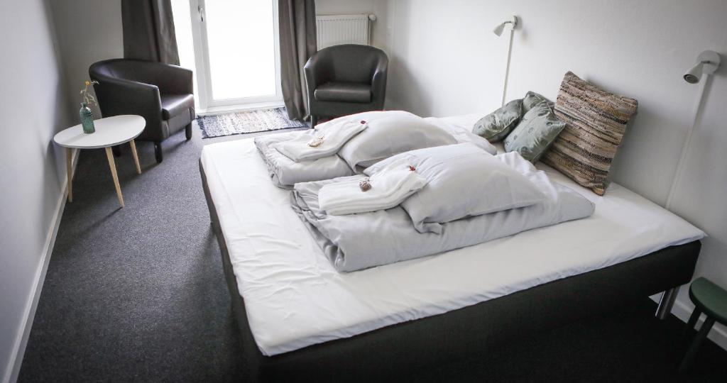 希茨海尔斯B&B by the Sea Hirtshals的一张位于房间的床,上面有三个枕头
