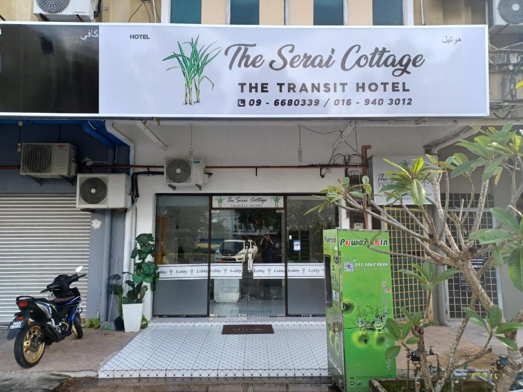 甘榜贡巴达The Serai Cottage Transit Hotel的停在餐厅前的摩托车
