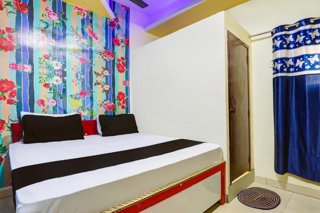 新德里OYO Golden Moment Guest House的一间卧室配有一张带色彩缤纷窗帘的床