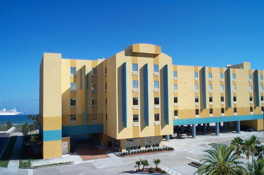 可可比奇可可海滩套房酒店 的一座棕榈树环绕的建筑,位于大海前