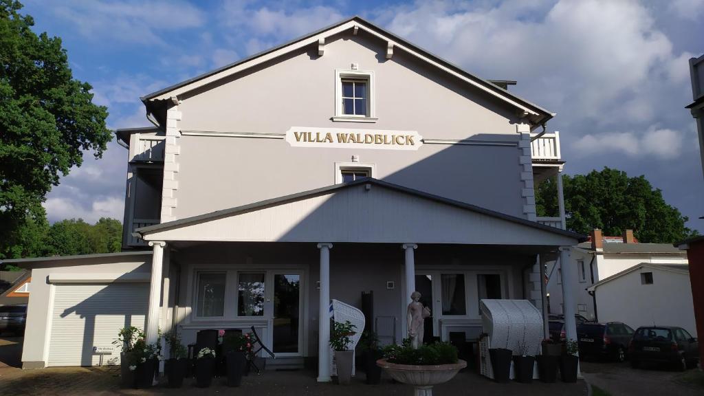 巴贝Villa Waldblick的白色的建筑,上面有标志