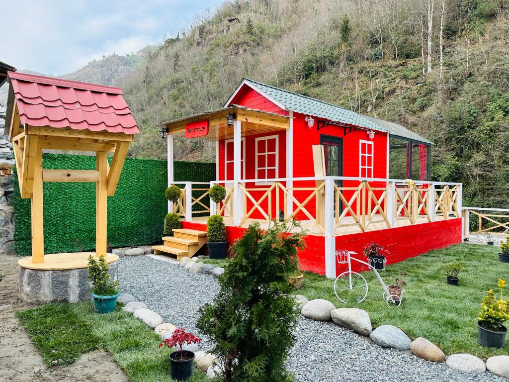 艾德亚耶拉西River Land Rize的院子里带凉亭的红色小房子