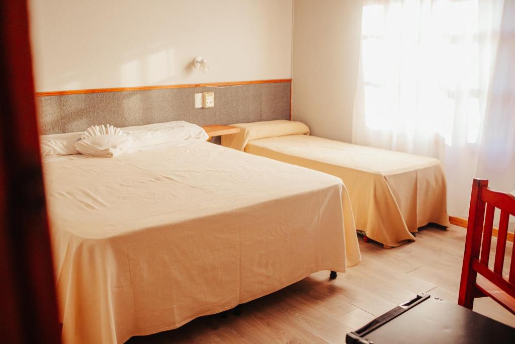 RealicóHOTEL REALICO的客房设有两张床和窗户。
