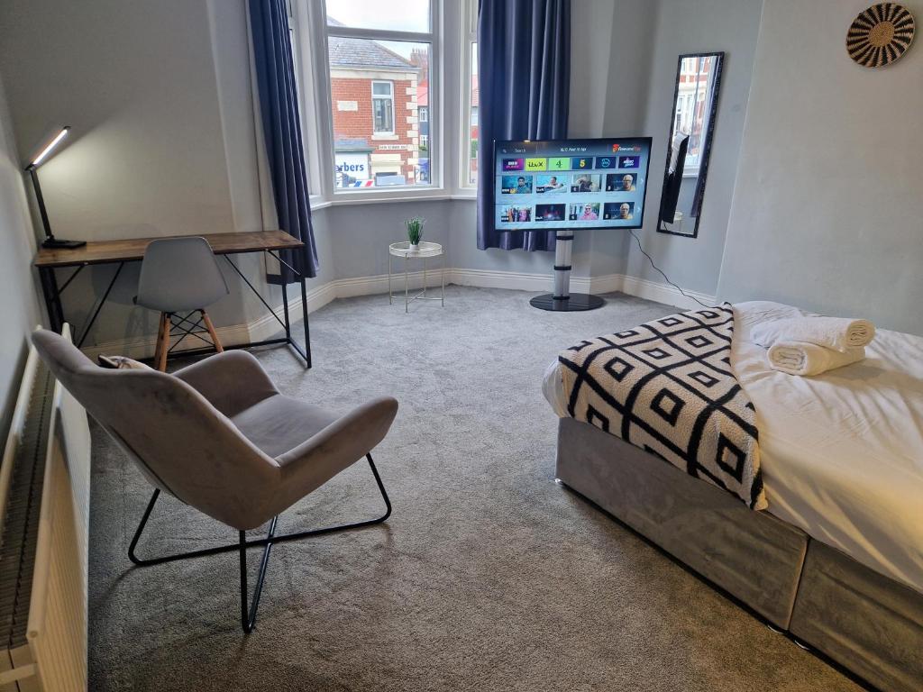 北希尔兹West Beck House - Newcastle 6的一间卧室配有一张床、一把椅子和电视