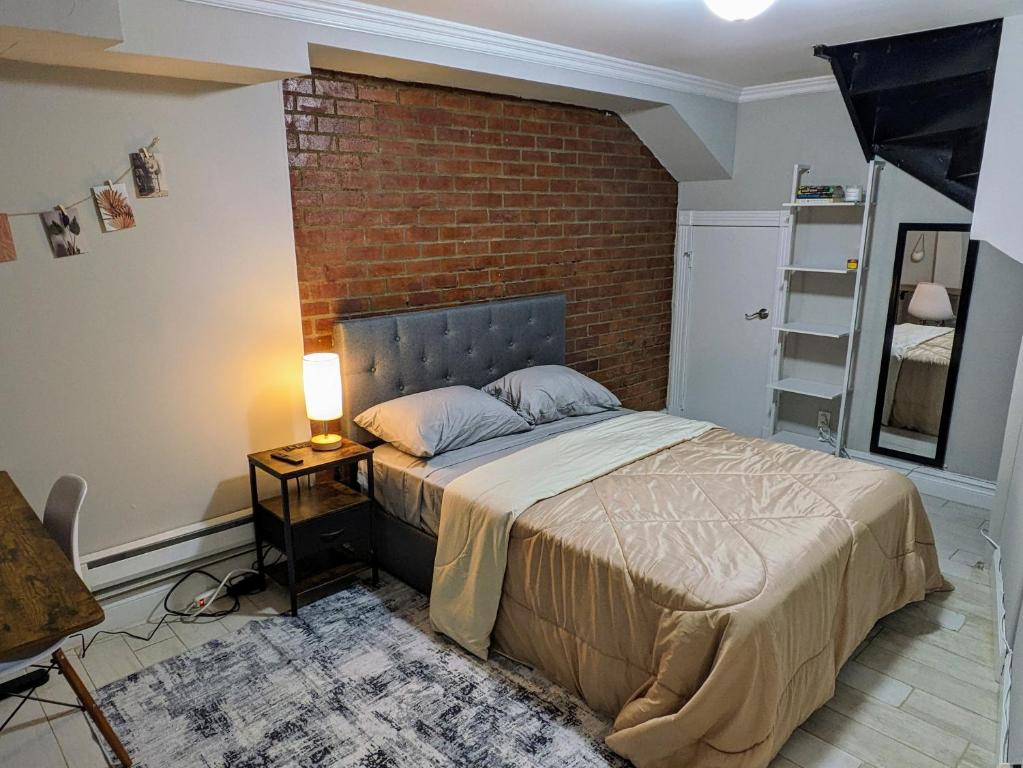 纽约Lovely Room at 3 bedroom Apt at the heart of East Village的一间卧室设有一张床和砖墙