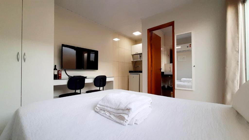 JaguariaívaFlat 01的卧室配有白色的床和毛巾