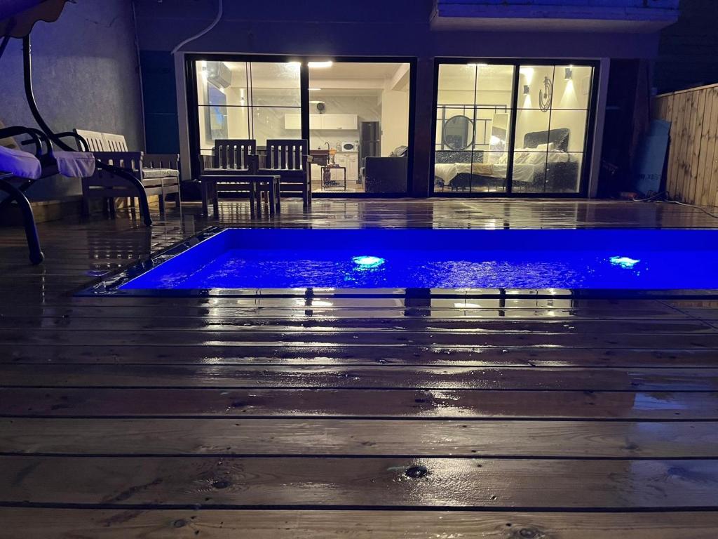 提比里亚מבית תכלת בית של חופש Allentown 21 אלנטאון 21的一层带蓝色灯光的游泳池