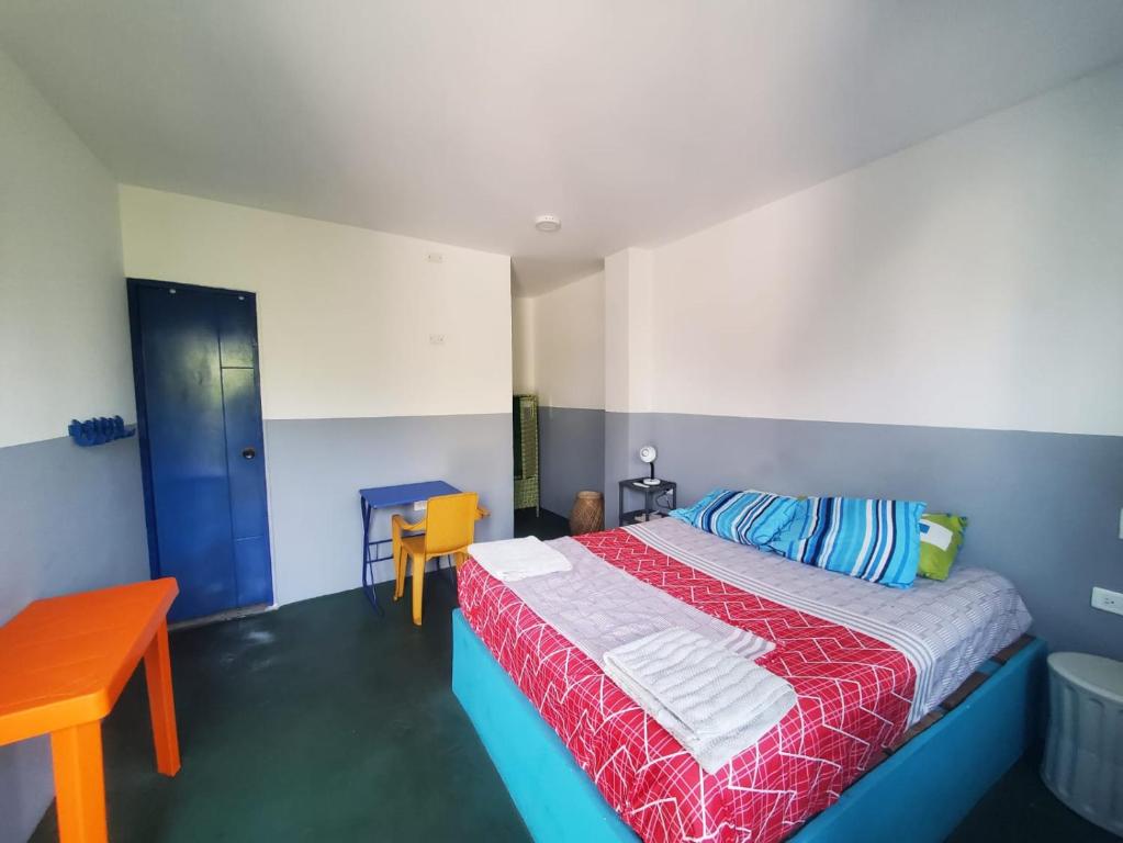卡塔赫纳Hotelito La Aventura, private rooms with AC的一间卧室配有一张带红色和蓝色毯子的床