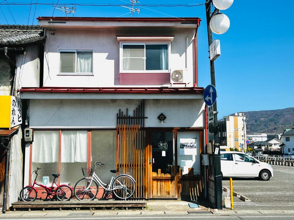 松本Guesthouse Azumaya的停放在大楼前的两辆自行车