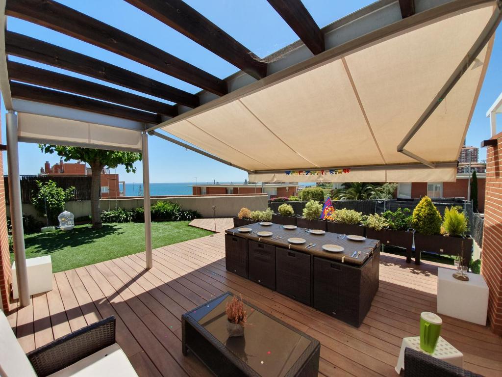 蒙特加特巴塞罗那海滩公寓的平台上配有大遮阳伞的天井