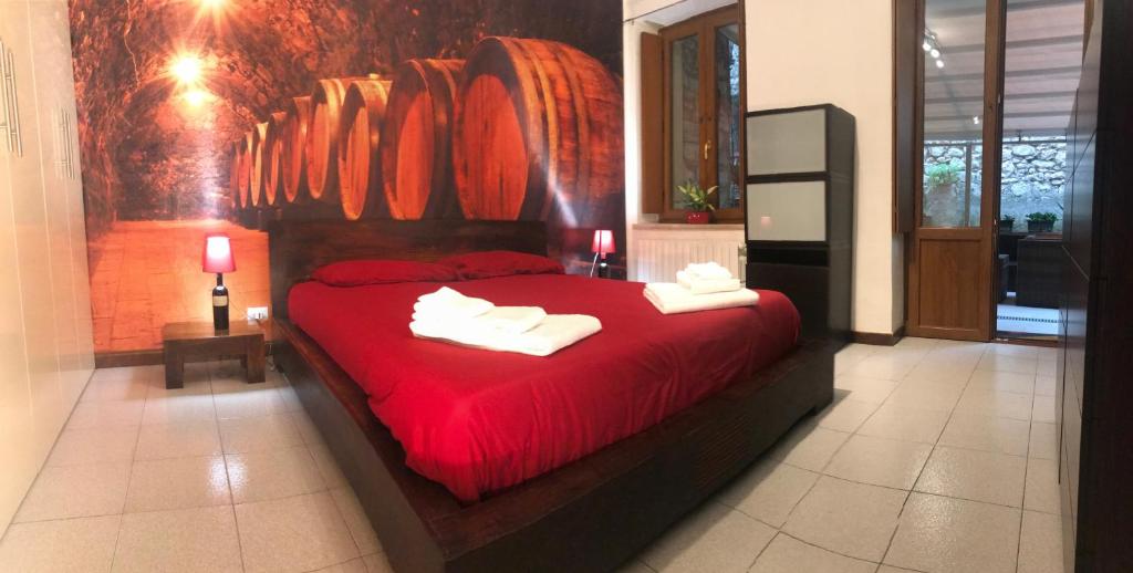 维罗纳Garden Wine Suite的一间卧室配有红色的床和毛巾