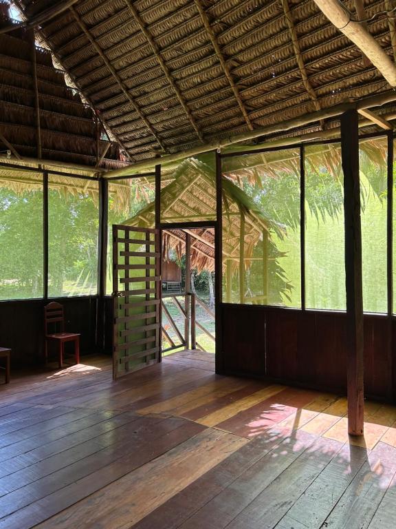利马Chamisal Jungle Hotel的一间空房间,铺有木地板,设有窗户