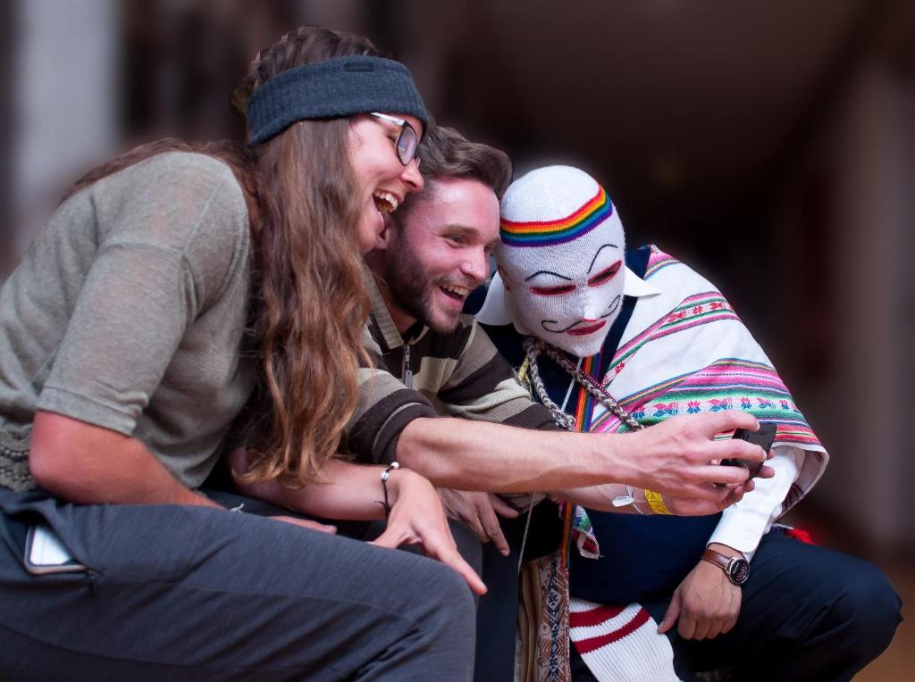 库斯科Pariwana Hostel Cusco的戴面具的男人拥抱的女人