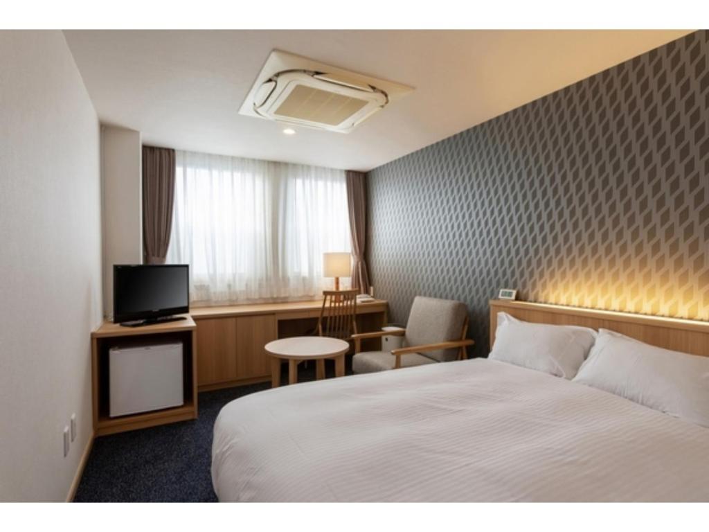 久留米市Suikoyen Hotel - Vacation STAY 46448v的酒店客房,配有床和电视