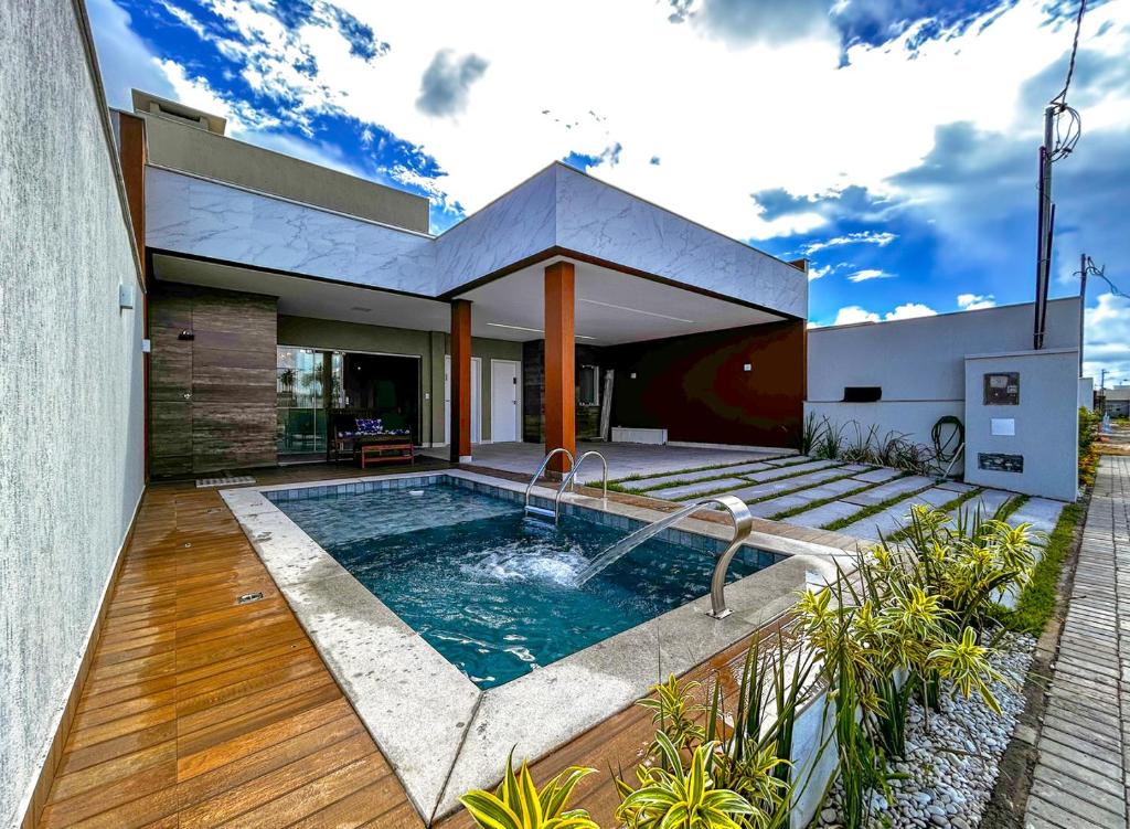 阿拉卡茹Casa com lazer proxima da Praia do Mosqueiro SE的后院带游泳池的房子