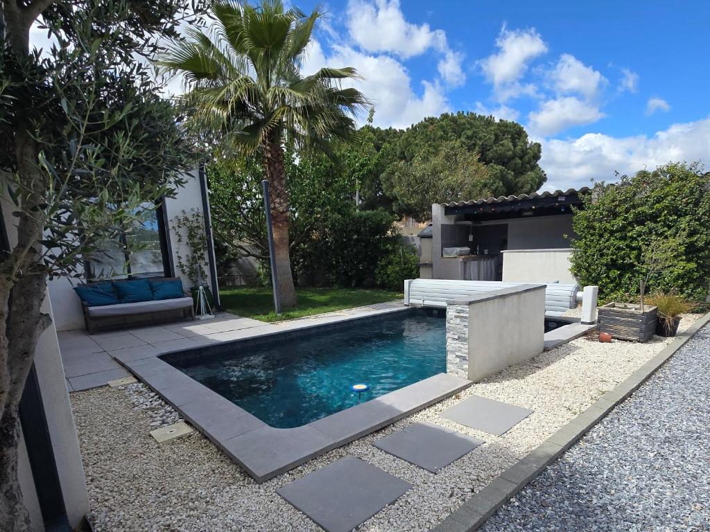 SauvianLe havre de paix - Maison familiale avec piscine et climatisation的房屋旁带长凳的游泳池