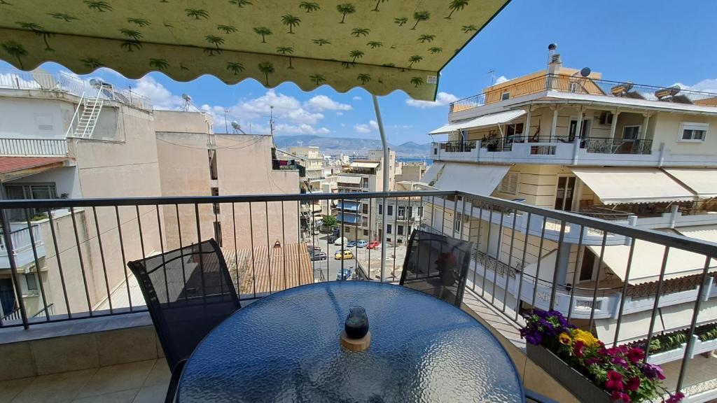 比雷埃夫斯Tomis Sea View Apartment的阳台的桌子,享有建筑的景色