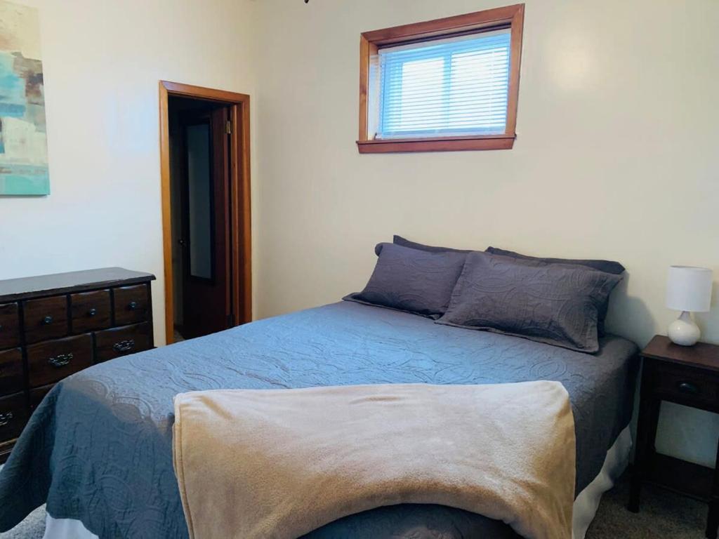 伊利2BR Erie Flat Near Gannon & Mercyhurst的一间卧室设有蓝色的床和窗户。