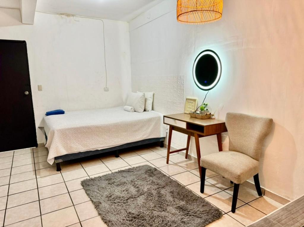 圣萨尔瓦多Hotel cielo的一间卧室配有一张床、一张桌子和一把椅子