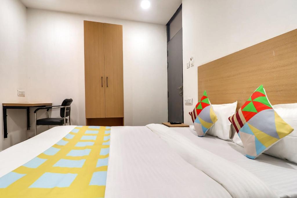 HasanganjOYO Home Basera Homes的卧室配有一张带彩色枕头的大型白色床。