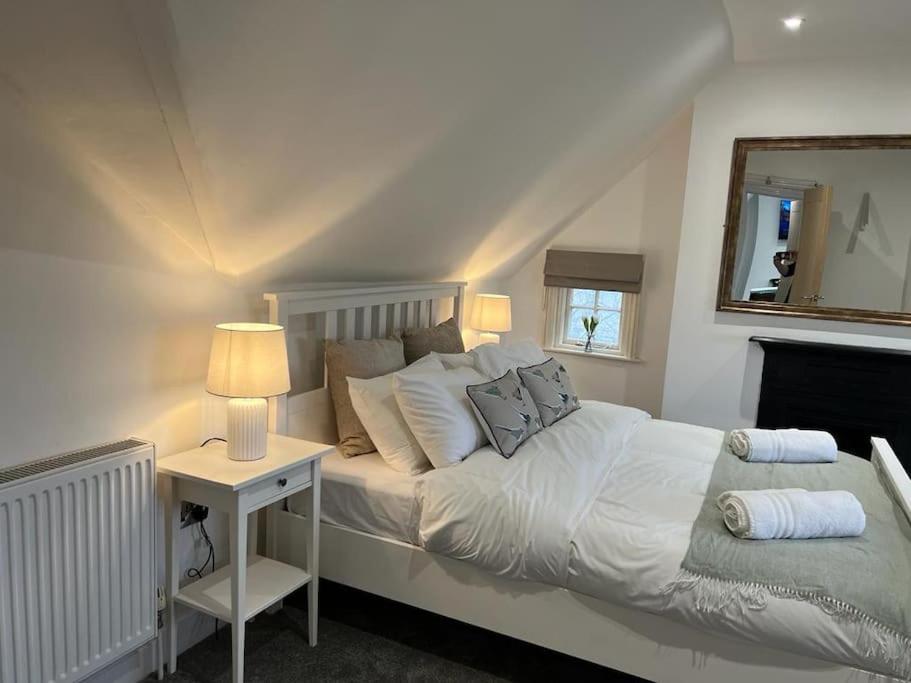 梅尔顿莫布雷The Loft at Scalford House的一间卧室配有一张床和一张带镜子的桌子