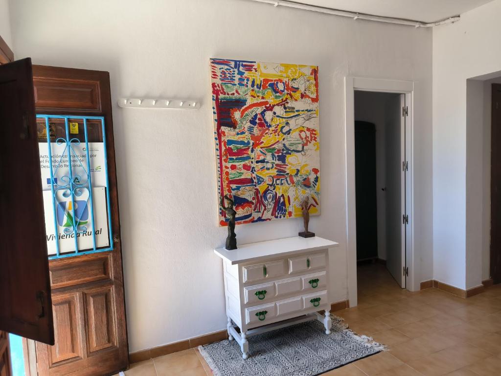 厄尔·波索·德·洛斯·弗莱尔Vivienda rural en Cabo de Gata的墙上有画作的房间和梳妆台