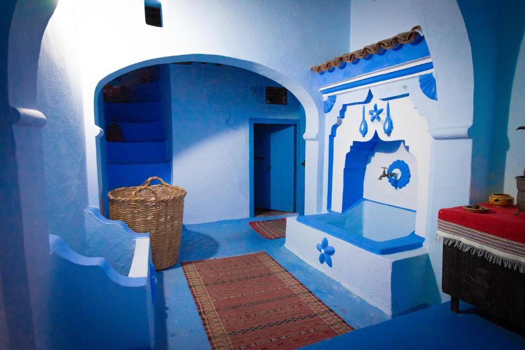 舍夫沙万达达迪奇雷夫摩洛哥传统庭院住宅的蓝色和白色的客房,地板上有一个篮子