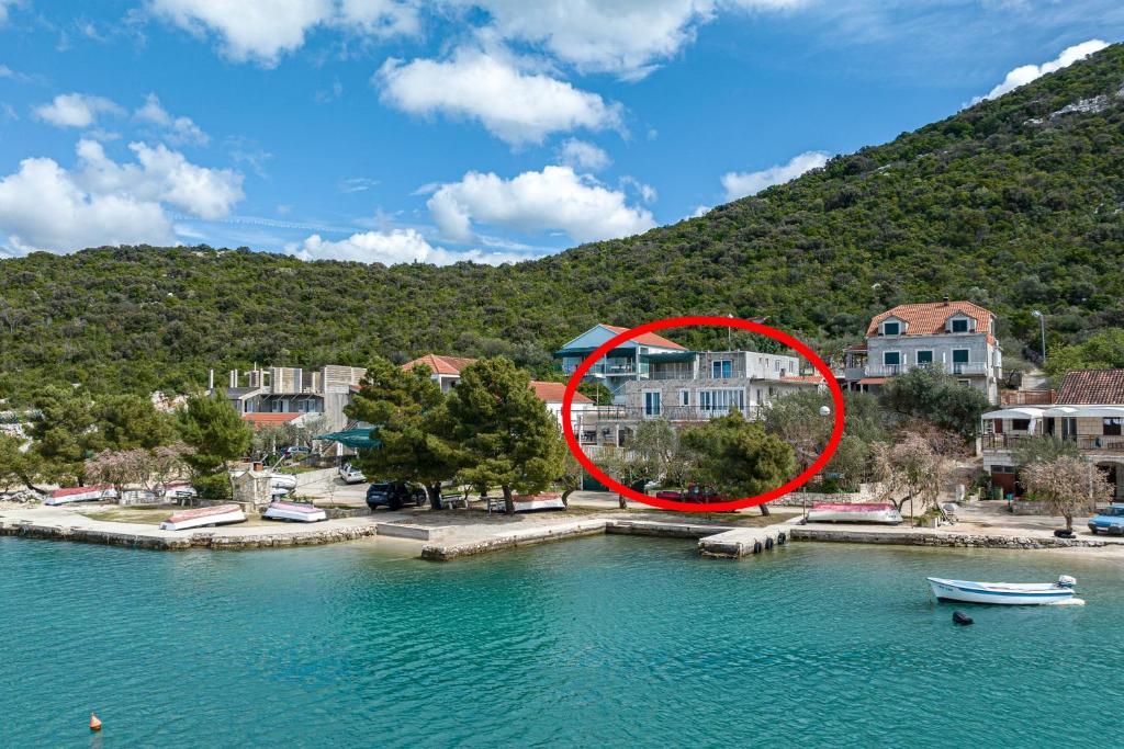 普特尼科维奇Apartments by the sea Luka Dubrava, Peljesac - 13632的房屋前水面上的小船