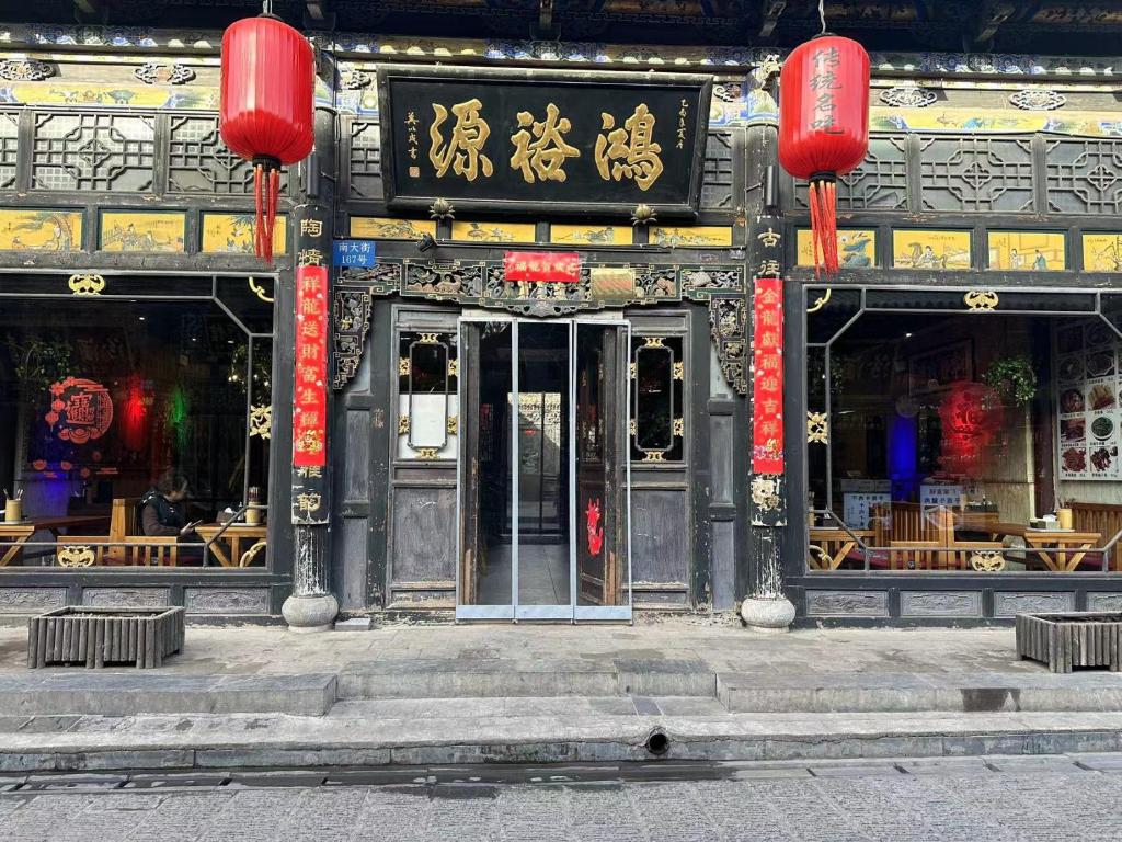 平遥Pingyao Hongyuyuan Guesthouse的建筑的入口,上面有中国标志