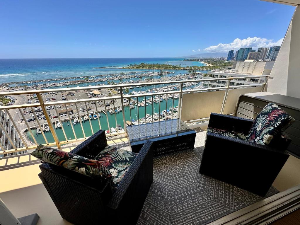 檀香山Serenity Waikiki ! Luxury Ocean Suite !的阳台配有两把椅子,享有海滩美景